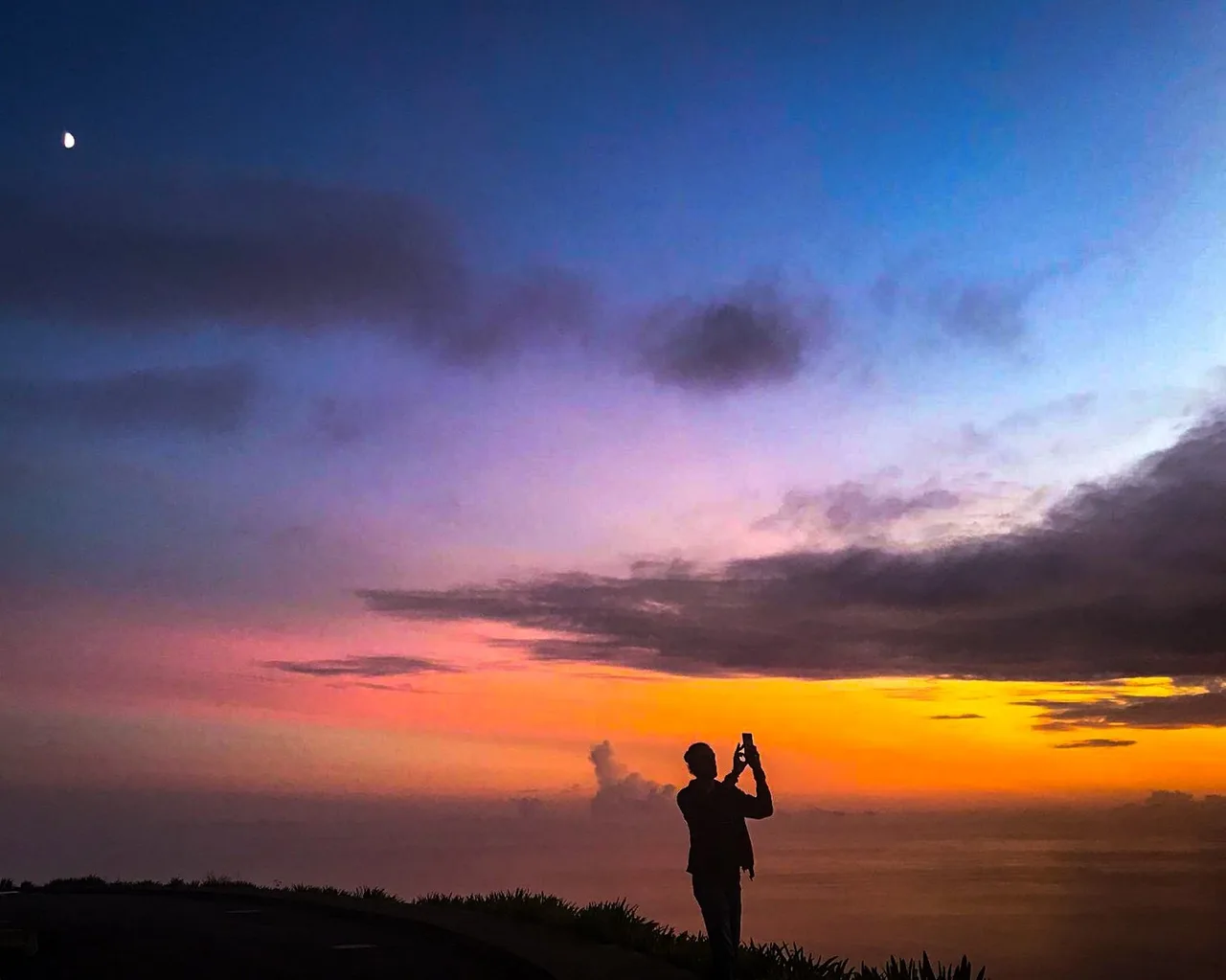Silhouette watching a colourful sunset from a Madeira coastal viewpoint