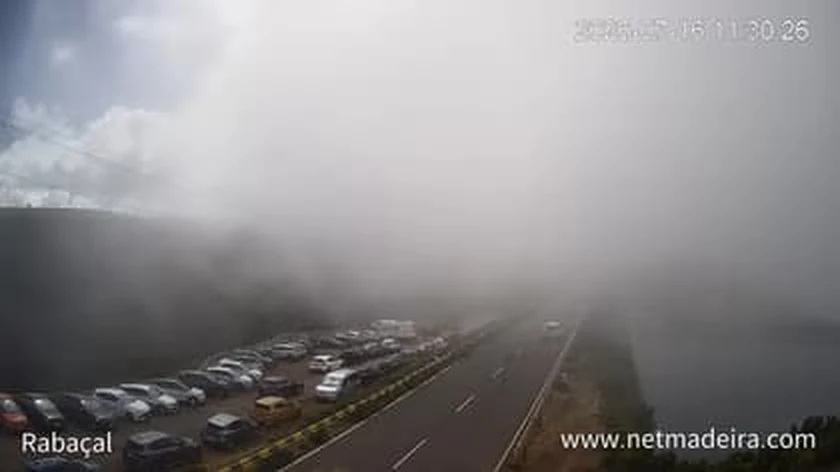 Rabaçal webcam frame, 26 July 2026 at 11:30, full car park and thick fog, beside our reading for the same minute: 55% cloud, 32 km visibility, 0 mm of rain, 18 degrees.