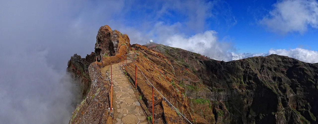 Stone path along the Pico do Arieiro ridge above a sea of clouds, Madeira